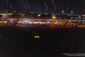 a building with lights and a plane in the background