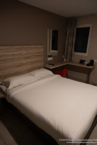 a bed with a wooden headboard and a desk
