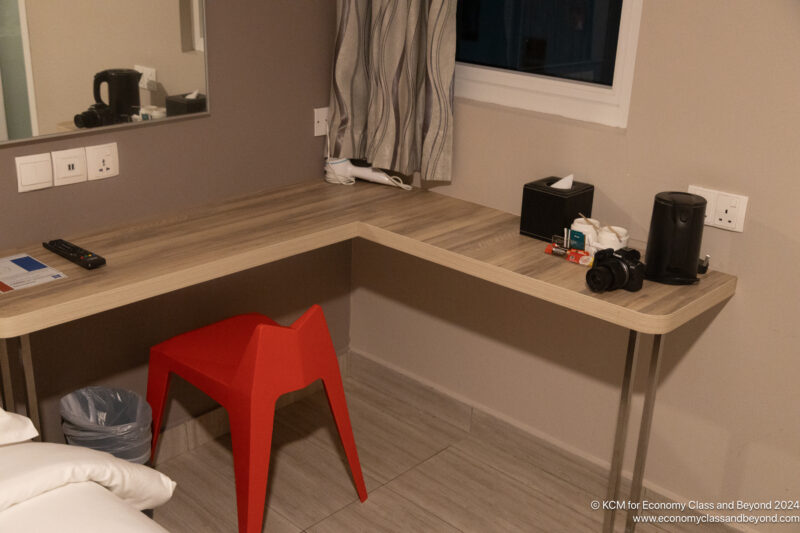 a desk with a red stool and a mirror