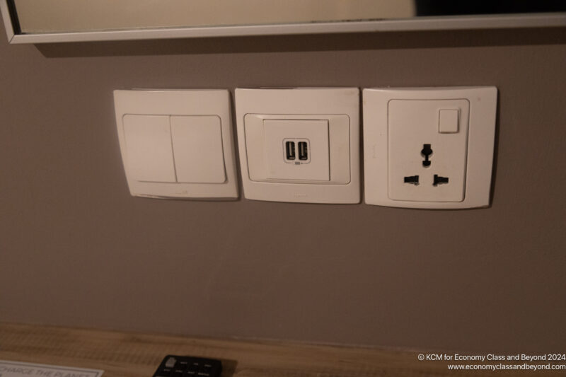 a wall with electrical outlets and a remote