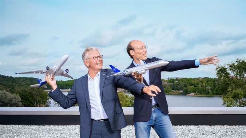 two men holding toy airplanes