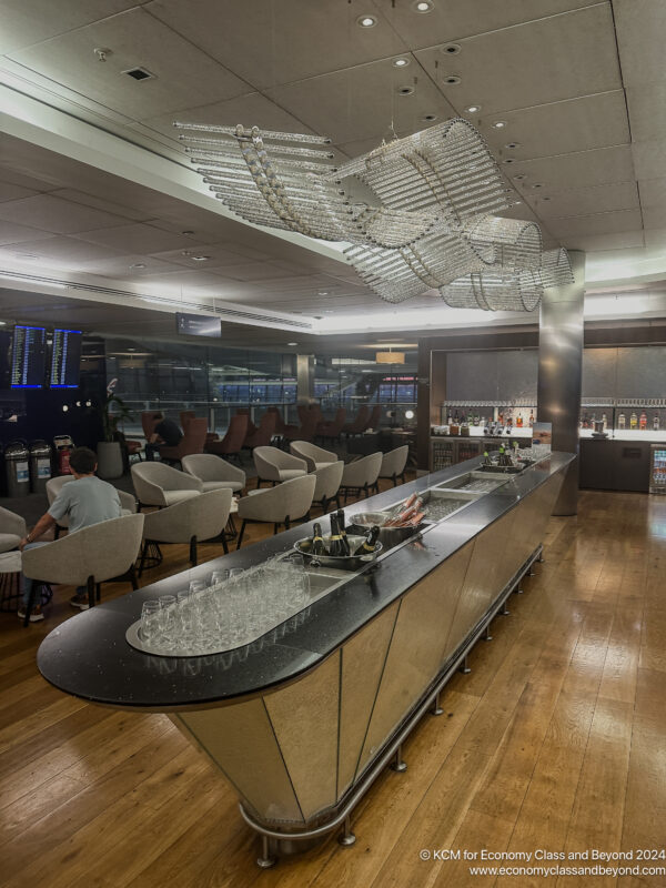 a bar with a long counter and chairs in a room