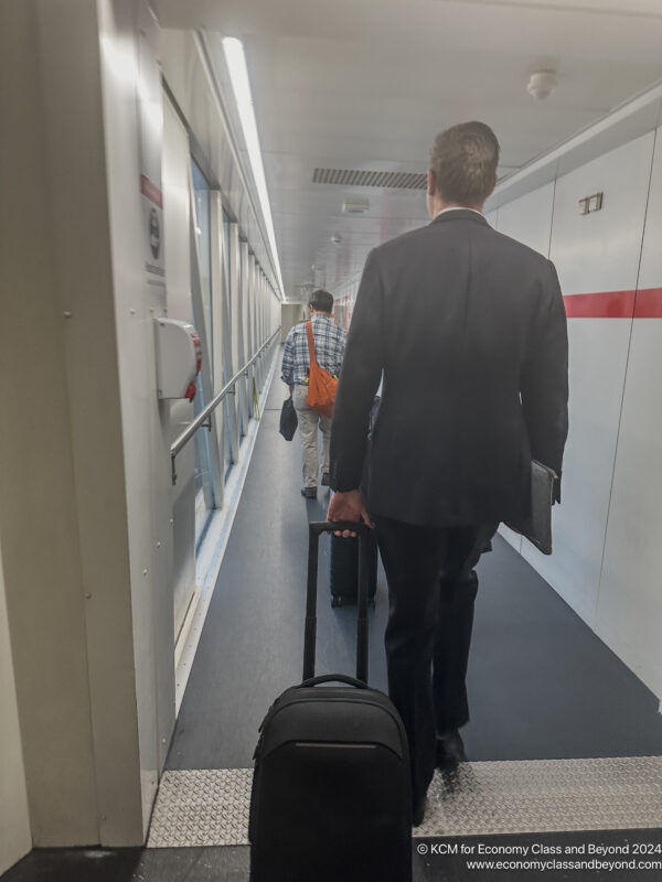 a man in a suit pulling a suitcase