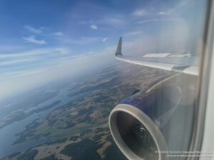 an airplane wing and engine in the sky