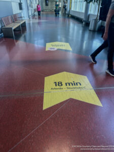 a person walking on a red floor with yellow signs on it
