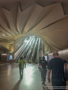 people walking in a tunnel with escalators