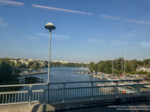 a bridge over a body of water with boats and a city in the background