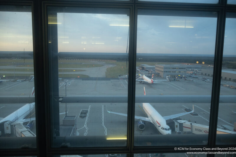 a window with a view of an airport and airplanes