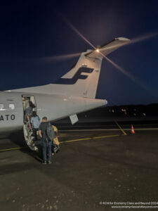 people boarding an airplane at night