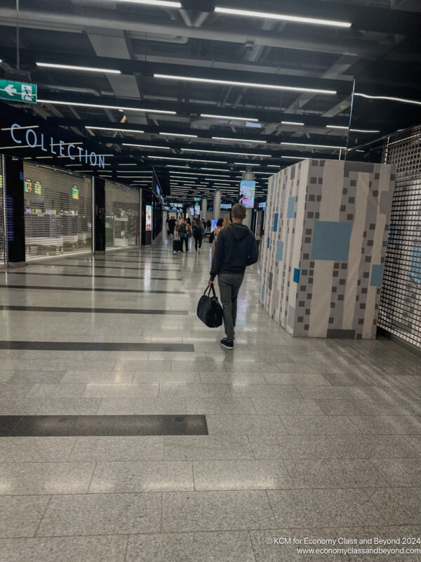 a man walking in a large room with a large wall and signs