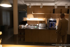 a person standing in front of a counter with a coffee machine