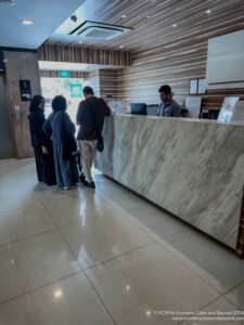 people standing at a counter in a lobby