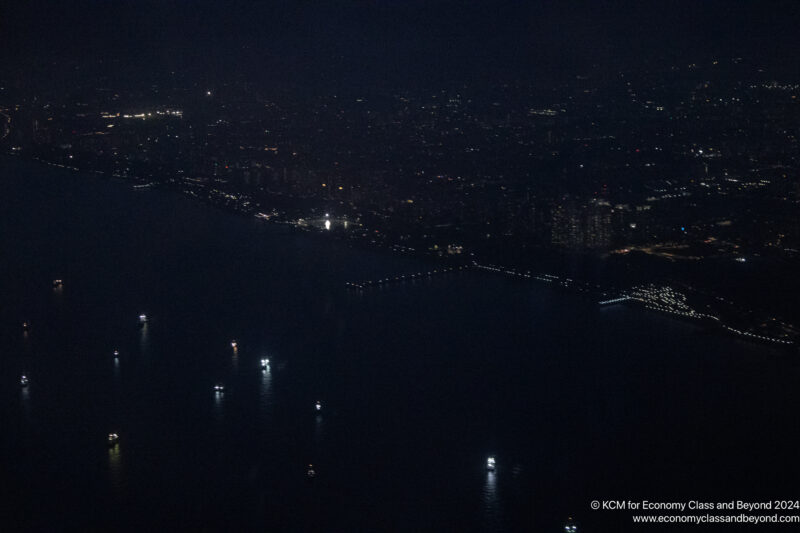 a city at night with lights on the water