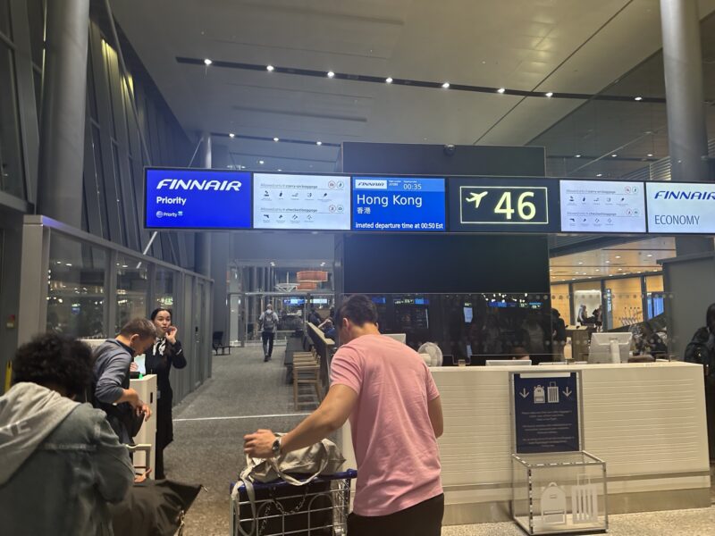 a man standing in a terminal with a luggage cart