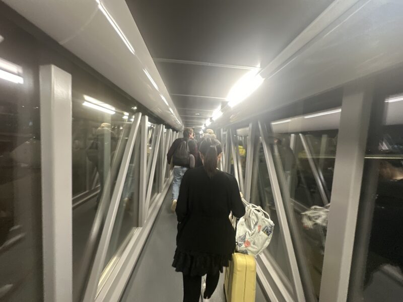 a group of people walking down a bridge with luggage