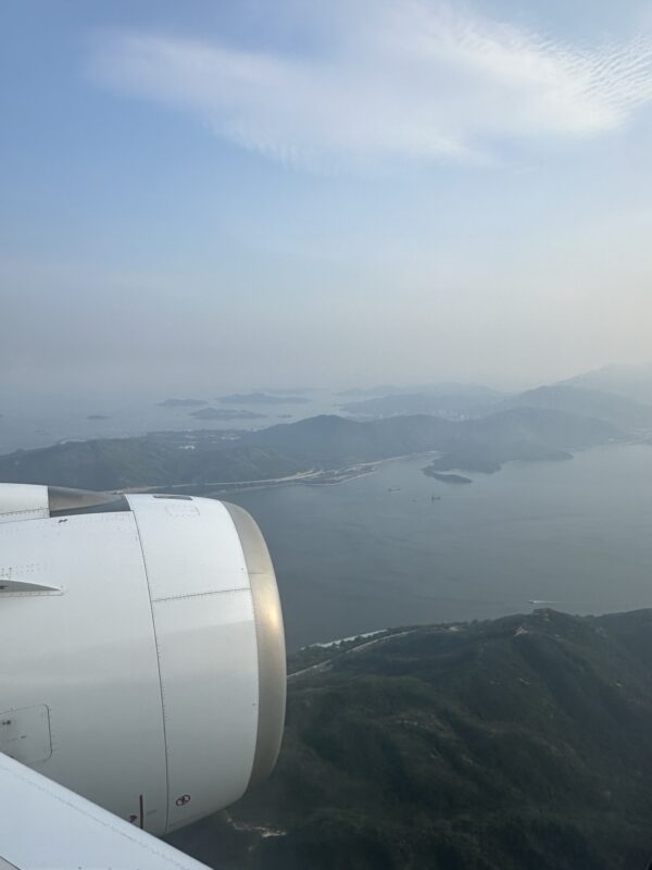 an airplane wing and view of land and water