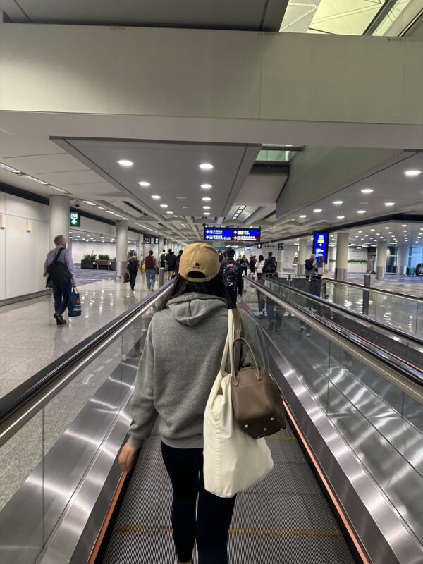 a woman walking on an escalator in an airport