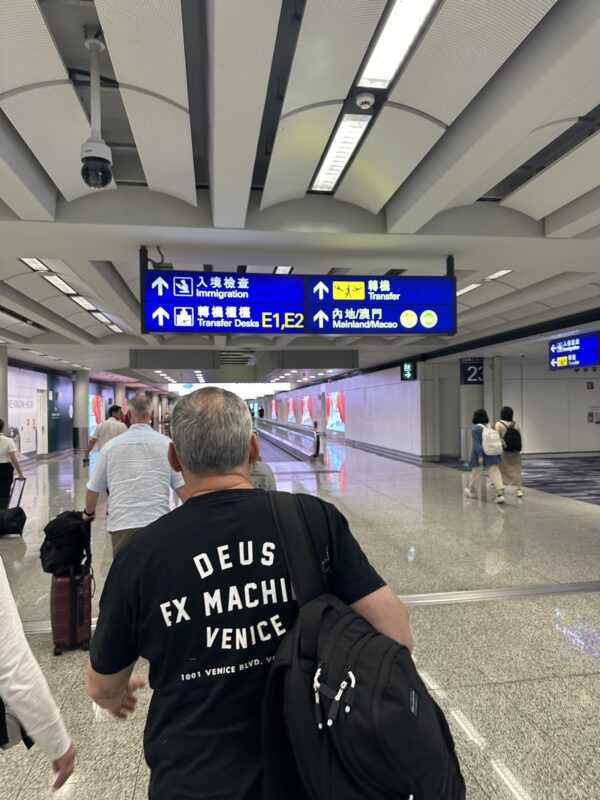 a man walking in a hallway with a sign above him