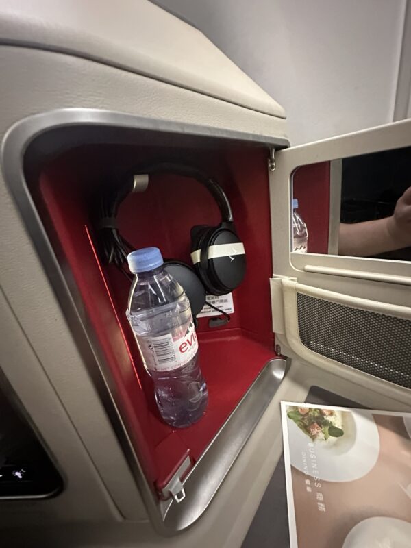 a bottle and headphones in a shelf