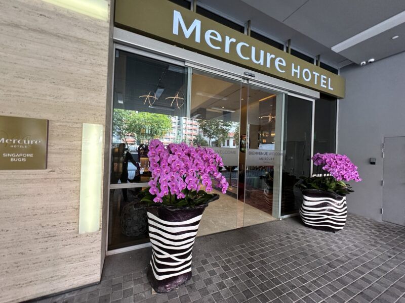 a hotel entrance with purple flowers