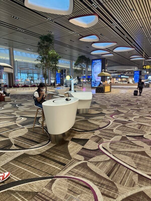 a woman sitting at a desk in an airport