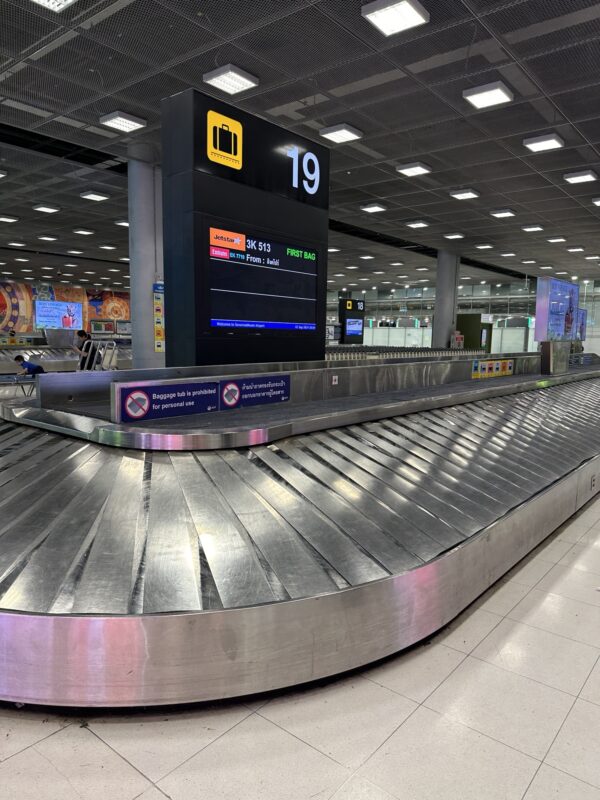 a baggage claim area with a sign