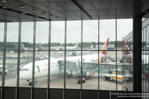 a large glass window with airplanes in the background