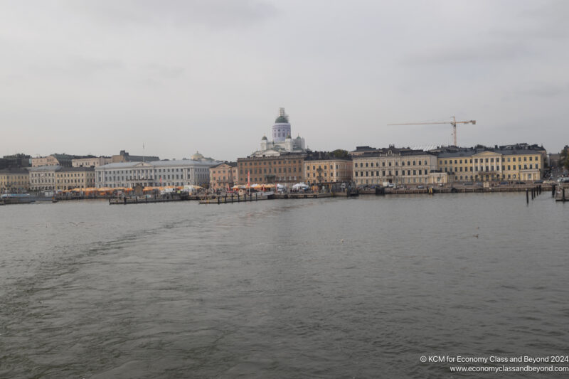 a body of water with buildings and cranes