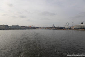 a body of water with buildings and ferris wheel