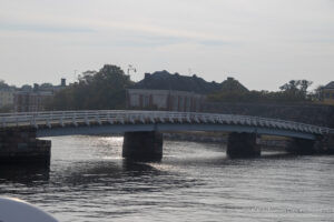 a bridge over water with a building in the background