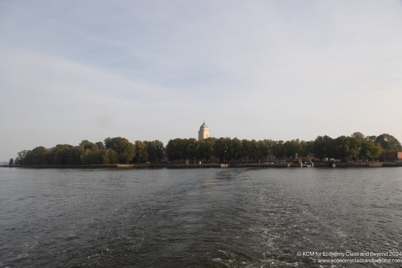 a body of water with trees and a building in the background