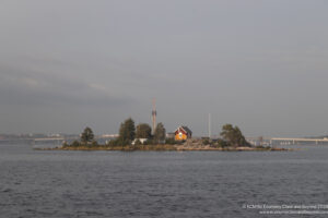 a small island with trees and a building in the distance