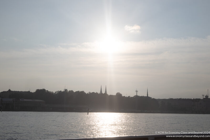 a body of water with buildings and trees in the background