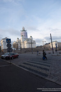 a large white building with a large dome and a building in the background