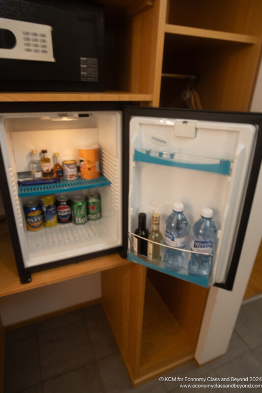 a mini fridge with drinks and bottles inside