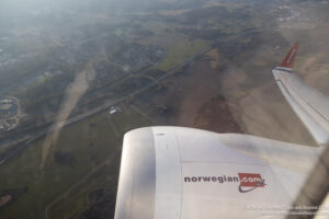 an airplane wing with a landscape in the background