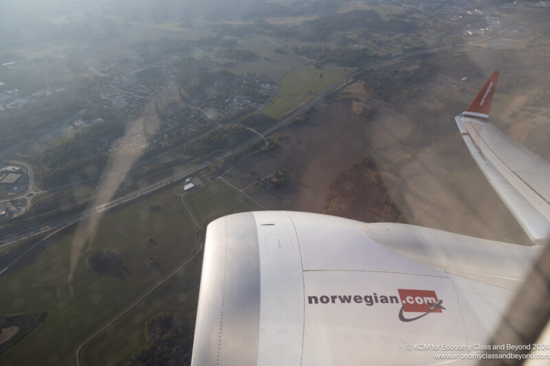 an airplane wing with a landscape in the background