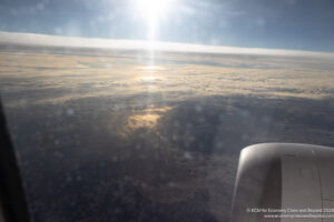 a view of clouds and the sun from an airplane window