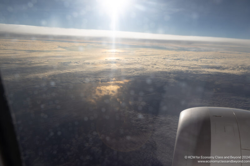 a view of clouds and the sun from an airplane window