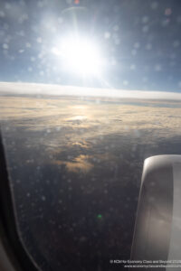 a view of clouds and the sun from an airplane window