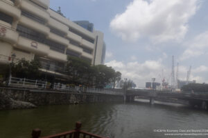 a river with a bridge and a building in the background