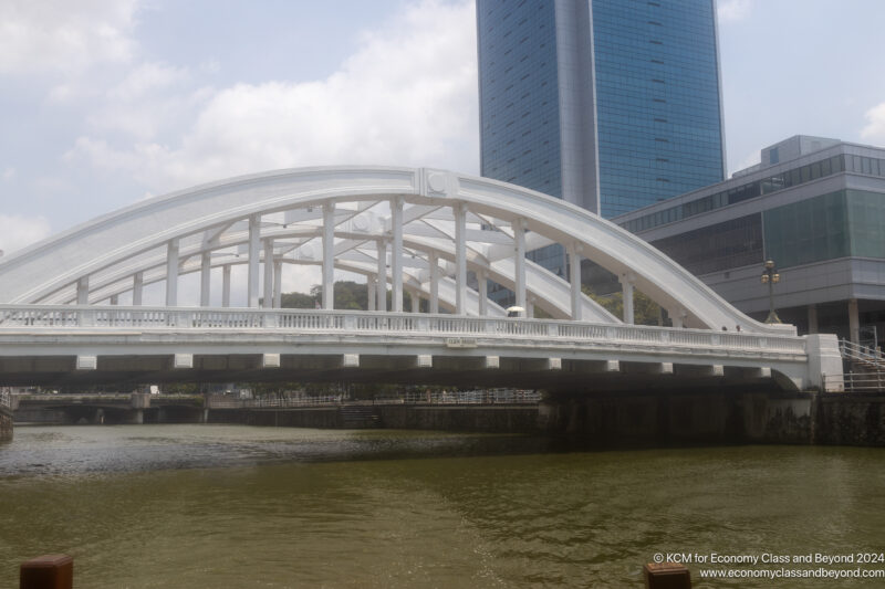 a bridge over water with a tall building in the background