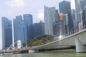 a bridge over water with a statue of a lion and a city in the background