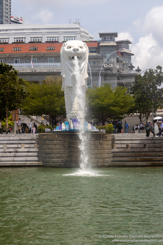 a statue of a lion with a fountain in front of a building