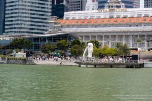 a group of people walking on a bridge over water with a statue of a lion