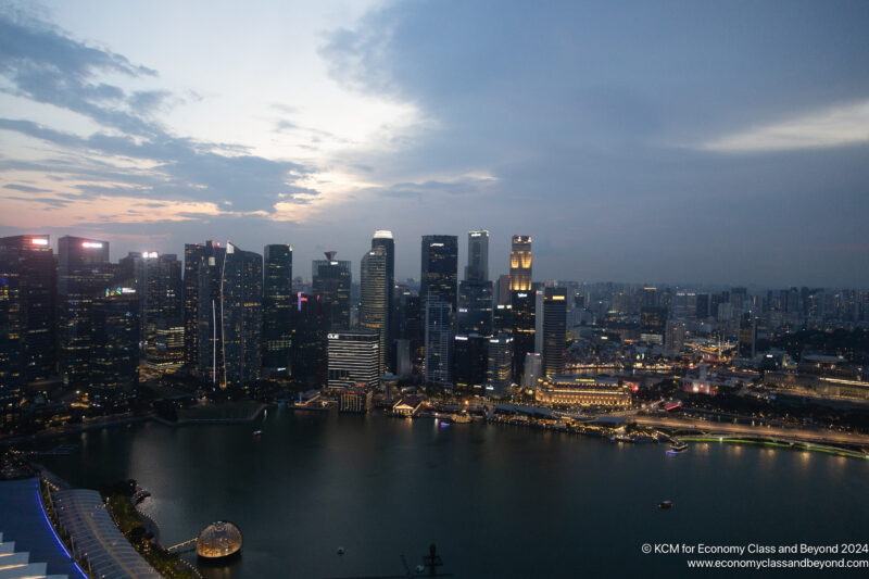 a city skyline with lights and a body of water