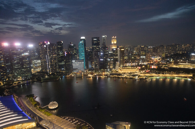 a city skyline with lights and a body of water