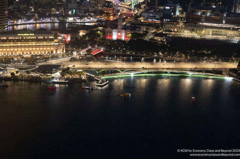 a city at night with lights on the water