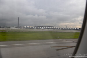a runway with a row of buildings and grass