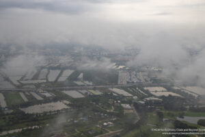 aerial view of a city with water and clouds